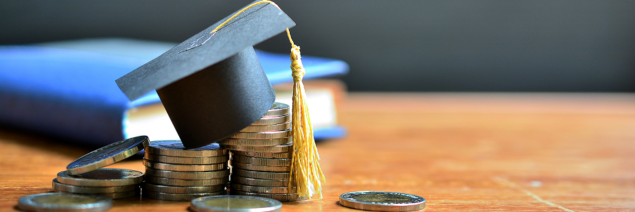 Moedas e capelo de formatura em uma mesa. Bolsa de estudo